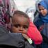 Una mujer y un bebé de un grupo de más de 600 inmigrantes rescatados en el mar Mediterráneo llegan al puerto italiano de Catania el 14 de mayo de 2015