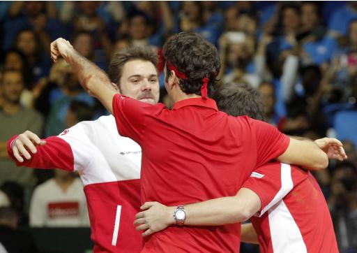 El suizo Stanislas Wawrinka, izquierda, festeja con Roger Federer luego que éste venció al francés Richard Gasquet en el primer partido de sencillos invertidos en la final de la Copa Davis en el estadio Pierre Mauroy de Lille, en el norte de Francia, el domingo 23 de noviembre de 2014. Federer ganó 6-4, 6-2, 6-2 para darle a Suiza una ventaja de 3-1 en la final y el primer título del torneo. (Foto AP/Christophe Ena)