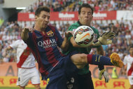 Lionel Messi (izquierda) dispuita una pelota con el arquero del rayo Vallecano, Tono, durante el partido del sábado 4 de octubre de 2014. (Foto de AP/Andres Kudacki)