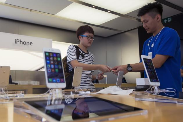 A woman buys the newly released iPhone 6 at an Apple store in Hong Kong