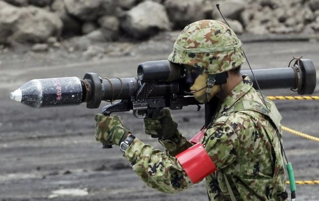 Un soldat japonais lors de manoeuvres près du Mont Fuji. Le Japon a assoupli mardi sa législation encadrant les exportations d'armes, remettant en question une politique vieille de près de cinquante ans qui revenait en pratique à les prohiber. /Photo d'archives/REUTERS/Kim Kyung-Hoon