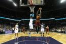 LeBron James, # 23 de los Cavaliers de Cleveland, hunde el balón marcado por Marvin Williams, #2 de los Hornets de Charlotte, durante su juego de la liga NBA, en el Time Warner Cable Arena, el 3 de febrero de 2016 Charlotte, Carolina del Norte.