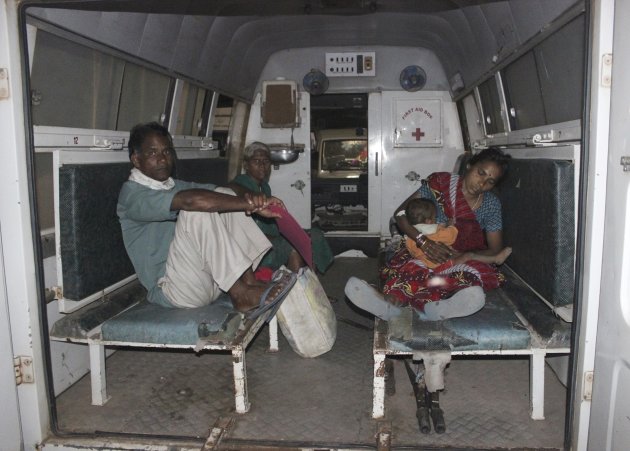A woman (R), who underwent a botched sterilization surgery at a government mass sterilization "camp", feeds her baby as she sits inside an ambulance while being moved to Chhattisgarh Institute of Medical Sciences (CIMS) hospital from a district hospital in Bilaspur, in the eastern Indian state of Chhattisgarh, November 10, 2014. Ten women died and 14 were in a serious condition after botched operations at a government mass sterilization "camp" in Chhattisgarh, officials said on Tuesday. The women fell ill on Monday, two days after surgery at a so-called family planning camp at a village. Such camps are held regularly in Chhattisgarh and other states as part of a long-running effort to control India's booming population. Picture taken November 10, 2014. REUTERS/Stringer (INDIA - Tags: HEALTH)