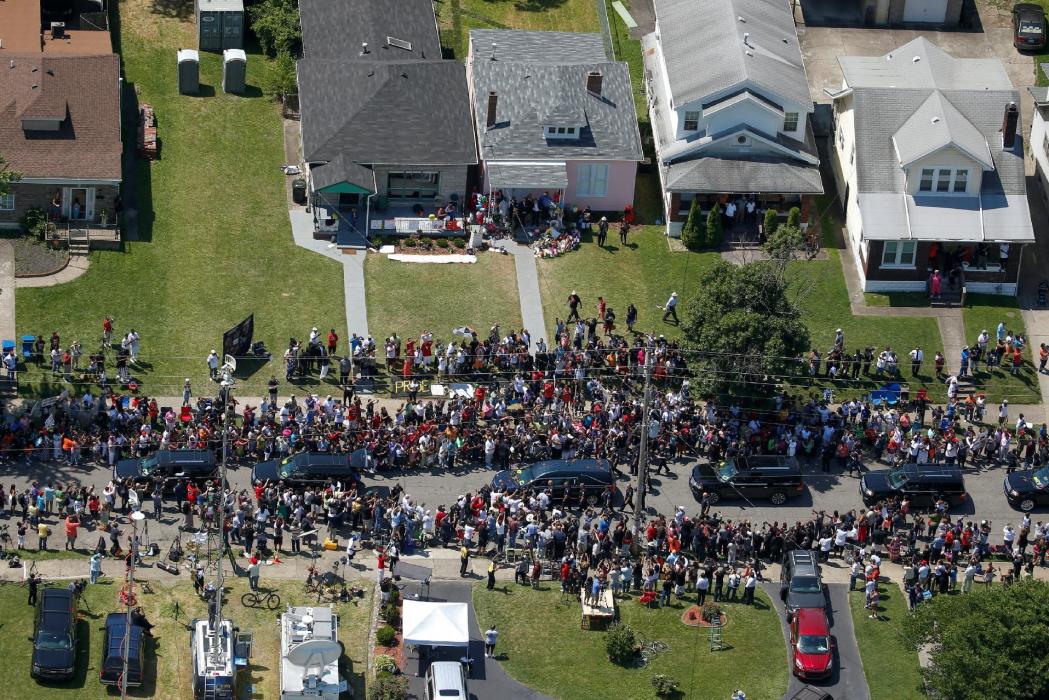 A hearse carrying the late boxing champion Muhammad Ali rides past his childhood home in Louisville, Kentucky