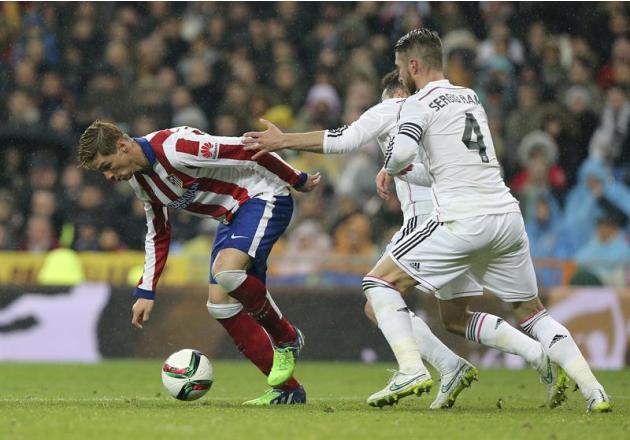 GRA356. MADRID, 15/01/2015.- El delantero del Atlético de Madrid Fernando Torres (i) controla el balón ante el defensa del Real Madrid Sergio Ramos, durante el partido de vuelta de los octavos de fina