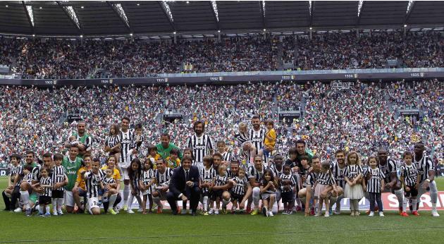 Players of Juventus pose for a photo with children before the start of their Italian Serie A soccer match against Cagliari at Juventus stadium in Turin