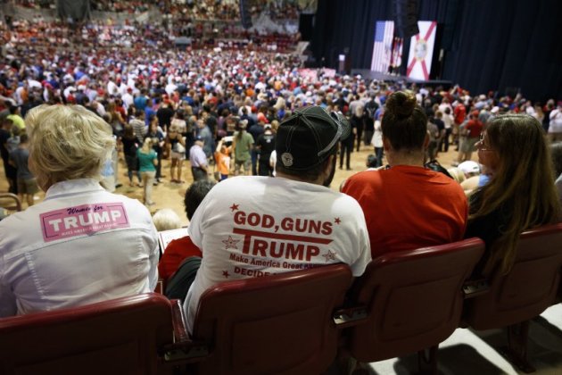 川普支持者穿著「上帝、槍枝、川普」標語的T恤。（美聯社）
