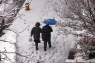 Casal caminha por rua encoberta de neve, em Nova York, 5 de março de 2015