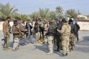 Sunni Tribal fighters in support of the Iraqi Army   carry their weapons as they stand guard, on the outskirts of Diyala province