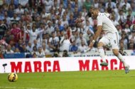 El delantero del Real Madrid Karim Benzema dispara a portería durante el derbi del fútbol español ante el Barcelona en Madrid, oct 25 2014. El Real Madrid ha acordado una "colaboración estratégica a largo plazo" con el fondo International Petroleum Investment Co (IPIC) de Abu Dabi, que fortalecerá el estatus del club como el más rico del mundo y ayudará a financiar las reformas del estadio Santiago Bernabéu. REUTERS/Sergio Perez