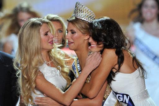 Dos aspirantes a reinas de belleza abrazan a la ganadora del consurso de Señorita Ile de Frances 2014 Margaux Savarit (C), el 6 de diciembre de 2014. (AFP | Guillaume Souvant)