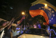 Opposition supporters wave a Venezuelan national flag from a car while they celebrate their victory on a street in Caracas December 7, 2015. REUTERS/Nacho Doce