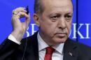 Turkish President Tayyip Erdogan removes his ear   piece at the Brookings Institute in Washington