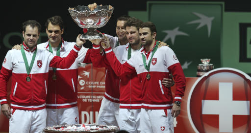 El equipo suizo alza el trofeo después de coronarse en la final de la Copa Davis con un triunfo de Roger Federer sobre el francés Richard Gasquet en duelo de sencillos invertidos en el estadio Pierre Mauroy de Lille, Francia, el domingo 23 de noviembre de 2014. (Foto AP/Peter Dejong)