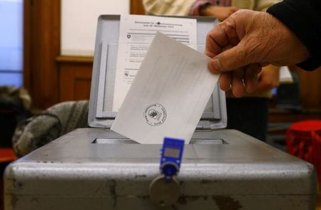 A man casts his voting ballot at the polling station in the Spitalacker school in Bern November 29, 2014. Switzerland votes this weekend on three initiatives, the Ecopop-immigration, the Swiss National Bank gold initiative, and lump-sum taxation. REUTERS/Ruben Sprich