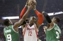 Dwight Howard, de los Rockets de Houston, salta hacia la cesta entre Rajon Rondo y jared Sullinger, de los Celtics de Boston, en el encuentro del sábado 1 de noviembre de 2014 (AP Foto/Pat Sullivan)