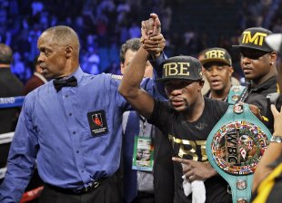 Floyd Mayweather shows off his belts after beating Marcos Maidana on Sept. 13. (AP)