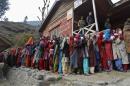 Voters line up to cast their votes outside a polling station during the first phase of the Jammu and Kashmir state assembly elections at Baba Nagri