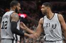 Tim Duncan (21), de los Spurs de San Antonio, felicita a su compañero LaMarcus Aldridge por un enceste durante el encuentro ante los Grizzlies de Memphis, el viernes 25 de marzo de 2016 (AP Foto/Darren Abate)