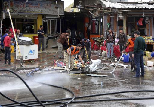 Varias personas limpian el lugar donde ocurrió un atentado con bomba en una calle llena de ferreterías y un restaurante, en un vecindario de la capital iraquí, el sábado 7 de febrero de 2015. El toque de queda que llevaba impuesto en Bagdad desde hace una década concluyó el domingo 8 de febrero a la medianoche, horas después que varias bombas en la capital y sus alrededores mataron a por lo menos 40 personas, un duro recordatorio de los peligros que todavía acechan en este país bajo ataque del grupo Estado Islámico. (Foto AP/Karim Kadim)