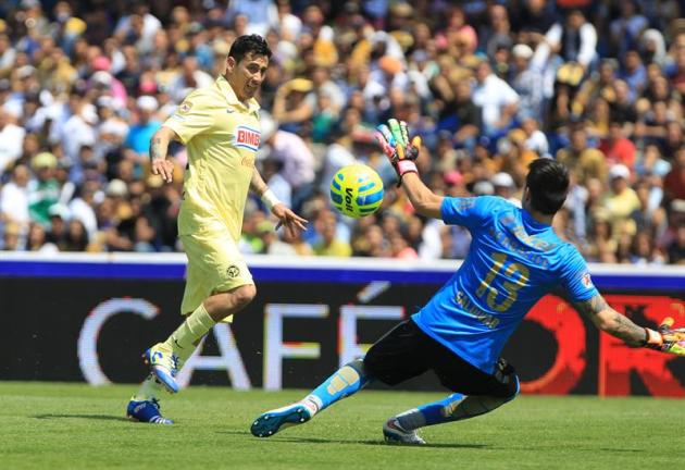 MEX11. CIUDAD DE MÉXICO (MÉXICO), 22/02/2015.- El jugador del América Rubens Sambueza (i) trata de anotar un gol ante el portero del Pumas Alfredo Saldivar (d) hoy, domingo 22 de febrero de 2015, dura