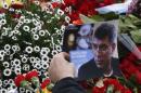 A visitor holds a photo at the site where Boris   Nemtsov was recently murdered, in central Moscow