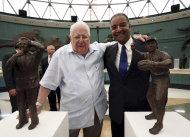 Juan Vené, izquierda, y Dámaso Blanco posan juntos a sus estatuas de bronce durante la ceremonia de exaltación al Salón de la Fama del béisbol de Venezuela, el martes 23 de septiembre de 2014. (AP Foto/Hector Bencomo)