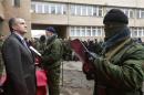 Aksyonov, Crimea's pro-Russian prime minister, stands as a member of a pro-Russian self defence unit takes an oath to Crimea government in Simferopol