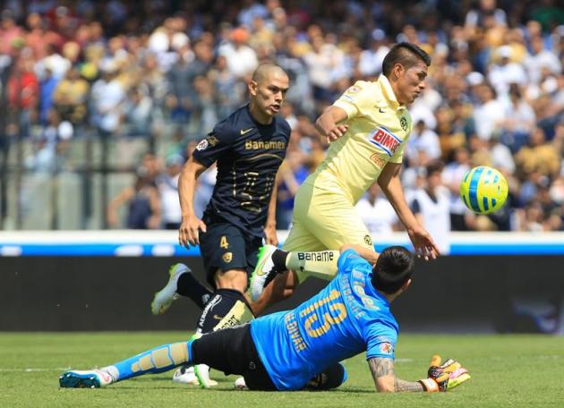 MEX21. CIUDAD DE MÉXICO (MÉXICO), 22/02/2015.- El jugador del América Moises Velazco (c) disputa el balón con el portero de Pumas Alfredo Saldivar (d) hoy, domingo 22 de febrero de 2015, durante un pa