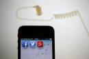 Illustration picture of application icons of Facebook   Twitter and Google on iPhone next to earphone set in Berlin