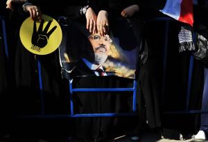 A woman holds the &quot;Rabia sign&quot; next to a&nbsp;&hellip;