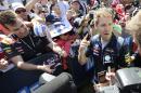 Red Bull driver Sebastian Vettel of Germany chats as he signs autographs for fans at Albert Park ahead of the Australian Formula One Grand Prix in Melbourne, Australia, Thursday, March 13, 2014. (AP Photo/Andrew Brownbill)