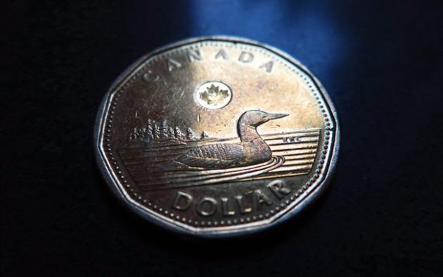 A Canadian dollar or loonie is pictured in North Vancouver, on March 5, 2014. The Canadian dollar was at its lowest levels since April 2009 on Monday morning as oil prices continued to retreat amid a bearish price forecast from investment bank Goldman Sachs. THE CANADIAN PRESS/Jonathan Hayward