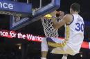 Stephen Curry, de los Warriors de Golden State, se cuelga del aro tras encestar frente a Gerald Wallace, de los Celtics de Boston, el domingo 25 de enero de 2015 (AP Foto/Ben Margot)