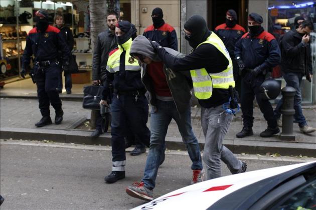 Mossos d'Esquadra escoltan a un detenido en la calle Gran de Sant Andreu durante la operación antiterrorista para desarticular una organización anarquista a la que se atribuyen diversos atentados con artefactos explosivos. EFE