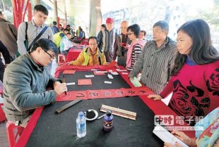 為炒熱年節氣氛，經發局昨日在第五市場旁舉辦「猴禮幸福」活動，民眾爭相索取書法老師書寫的春聯。（范揚光攝）