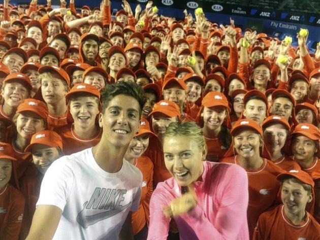 MLB01. MELBOURNE (AUSTRALIA), 13/01/2015.- La rusa Maria Sharapova (c-d) y el australiano Thanasi Kokkinakis (c-i) posan junto a un grupo de asistentes de cancha en el Rod Laver Arena de Melbourne (Au