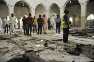 Personas inspeccionan la mezquita central de Kano, NIgheria, luego de varias explosiones en el sitio mataron a más de 120 personas e hirieron a 150 el viernes, 29 de noviembre del 2014. (Foto AP/Muhammed Giginyu)
