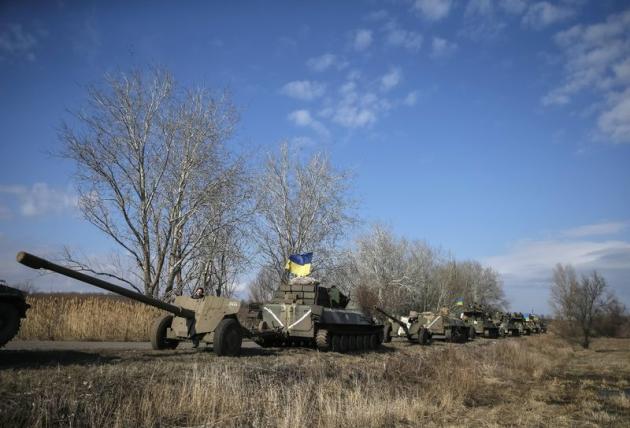 Convoi de véhicules de l'armée ukrainienne se retirant de la région de Debaltseve. Trois membres des forces gouvernementales ont été tués au cours de ces dernières vingt-quatre heures dans l'est de l'Ukraine, où plusieurs attaques séparatistes ont été recensées malgré le cessez-le-feu censé être entré en vigueur le 15 février. /Photo prise le 27 février 2015/REUTERS/Gleb Garanich