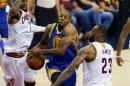 El jugador de los Golden State Warriors, Andre Iguodala (C), pasa por el medio de los jugadores de los Cleveland Cavaliers, Kyrie Irving (I) y LeBron James (D) durante el cuarto partido de la final de la NBA el 10 de junio de 2016 en Cleveland