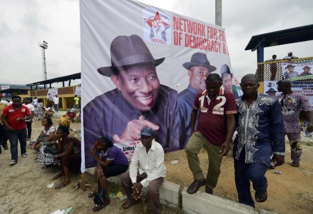 Des supporters près d'une affiche électorale du président nigérian Goodluck Jonathan, le 28 janvier 2015 à Port Harcourt