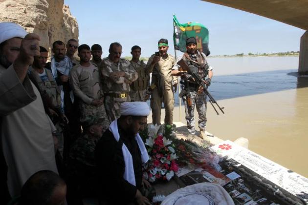 Unos miembros de las fueras de seguridad iraquíes y de las unidades de Movilización Popular rezan el 15 de abril de 2015 a orillas del río Tigris a su paso por Tikrit, donde se cree que el Estado Islámico asesinó a cientos de personas