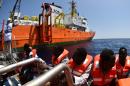 Des migrants montent à bord de l'Aquarius, après avoir été secourus le 24 mai 2016 en mer Méditerranée par SOS Méditerranée