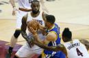 El escolta Stephen Curry (centro), de los Golden State Warriors, entre LeBron James e Iman Shumpert, de los Cleveland Cavaliers, en el cuarto partido de las finales de la NBA en Cleveland, Ohio, el 10 de junio de 2016