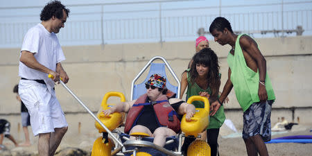 Des jeunes volontaires s'occupent d'une femme handicapée, le 29 juillet 2010 sur la plage du Prado à Marseille, dans le cadre de leur service civique