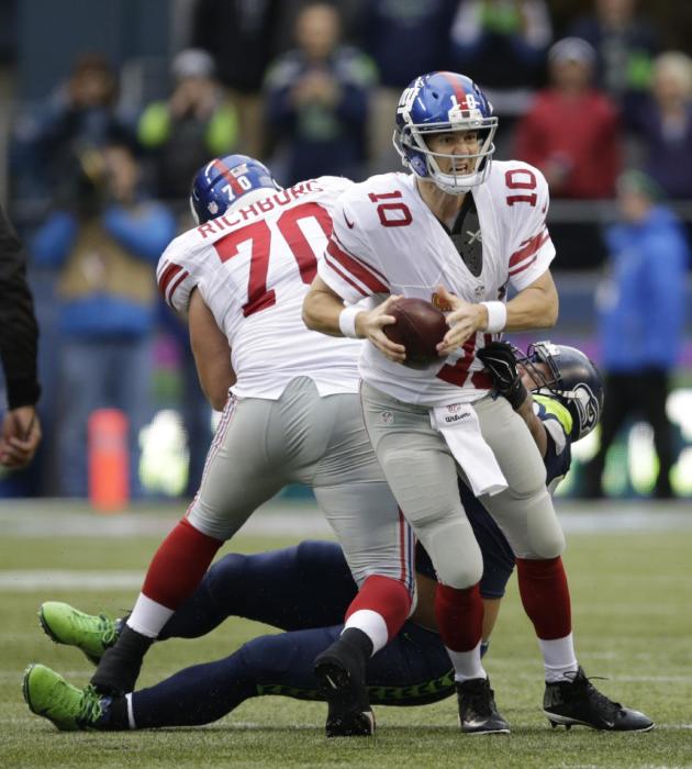 New York Giants, Eli Manning, mariscal de campo (10) SE RETIRO Por Seattle Seahawks tackle defensivo Jordan Hill en la Primera Mitad de la ONU Partido de fútbol de la NFL, Domingo, 09 de noviembre de 2014, en Seattle.  (AP Photo / Scott, E