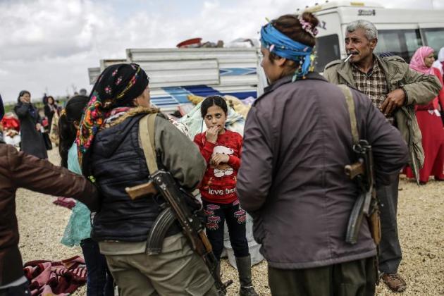 Unos kurdos sirios, junto a unos comatientes llegados a la ciudad de Kobane, el 30 de marzo de 2015
