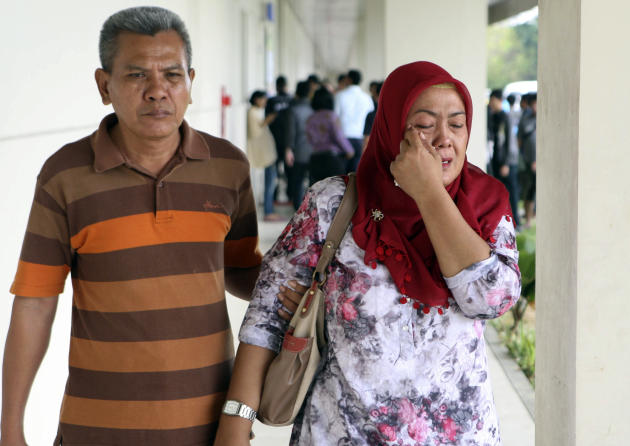 A relative of the passengers of AirAsia flight QZ8501 weeps as she.