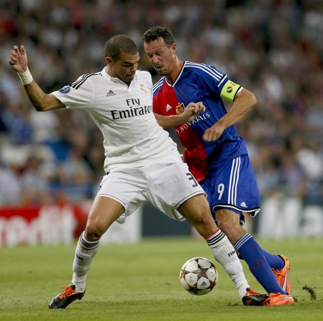 GRA572. MADRID. 16/09/2014.- El defensa portugués del Real Madrid Képler laveran "Pepe" (i.) lucha el balón con el delantero Marco Streller (d), del FC Basilea, durante el partido de la primera jornad