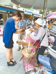 在行天宮外擺攤賣拜拜用品逾10年的林婆婆（右）把握最後一天招攬顧客。她哽咽落淚，表示小攤子收入要養活自己，「以後不能賣了，該怎麼辦？」（張潼攝）